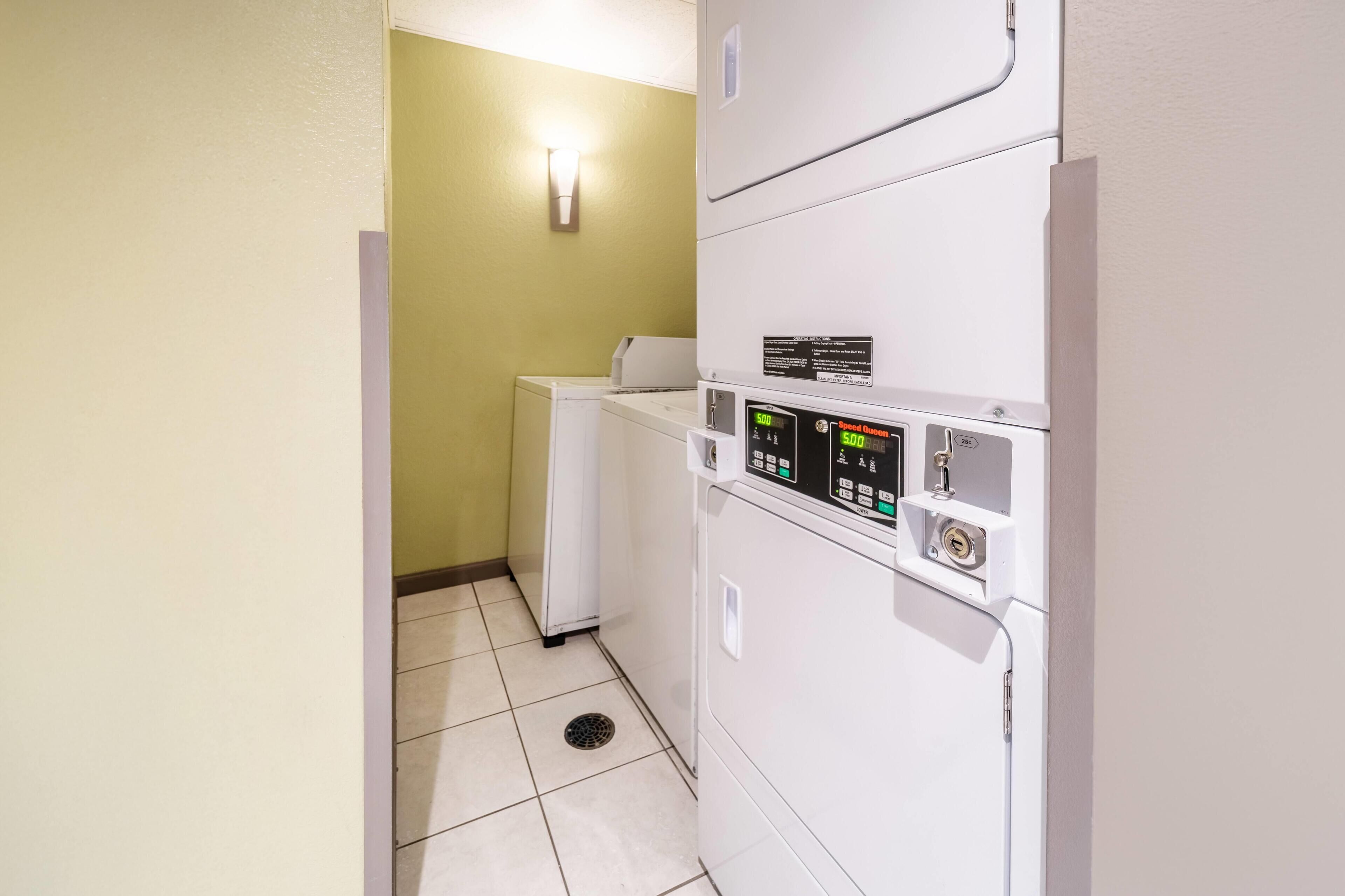 A laundry room with a washing machine, dryer, and control panel.