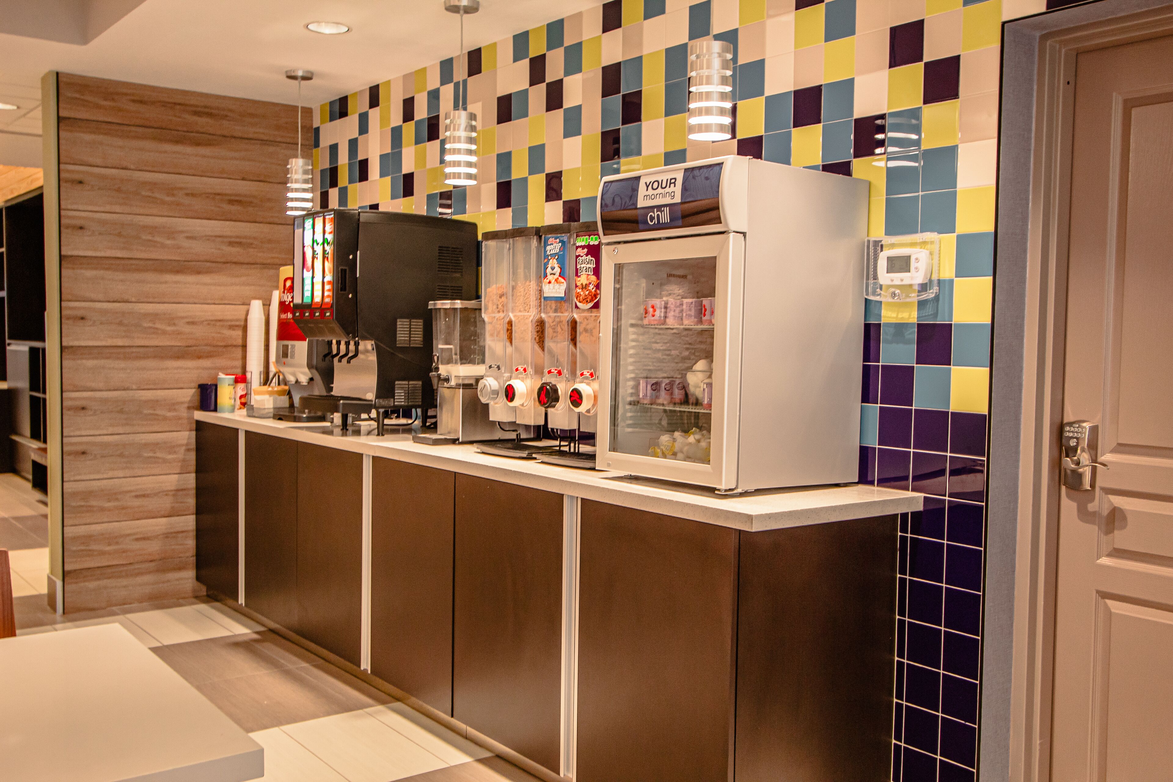 Een zelfbedieningsdrankenstation met diverse drankjes, een digitaal scherm en een koeltoog.