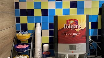 Un espace dédié au café, équipé d'une machine à café Folgers Select Brew, de tasses et de dosettes de café.