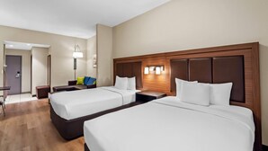Een hotelkamer met twee bedden, een bureau en een stoel.