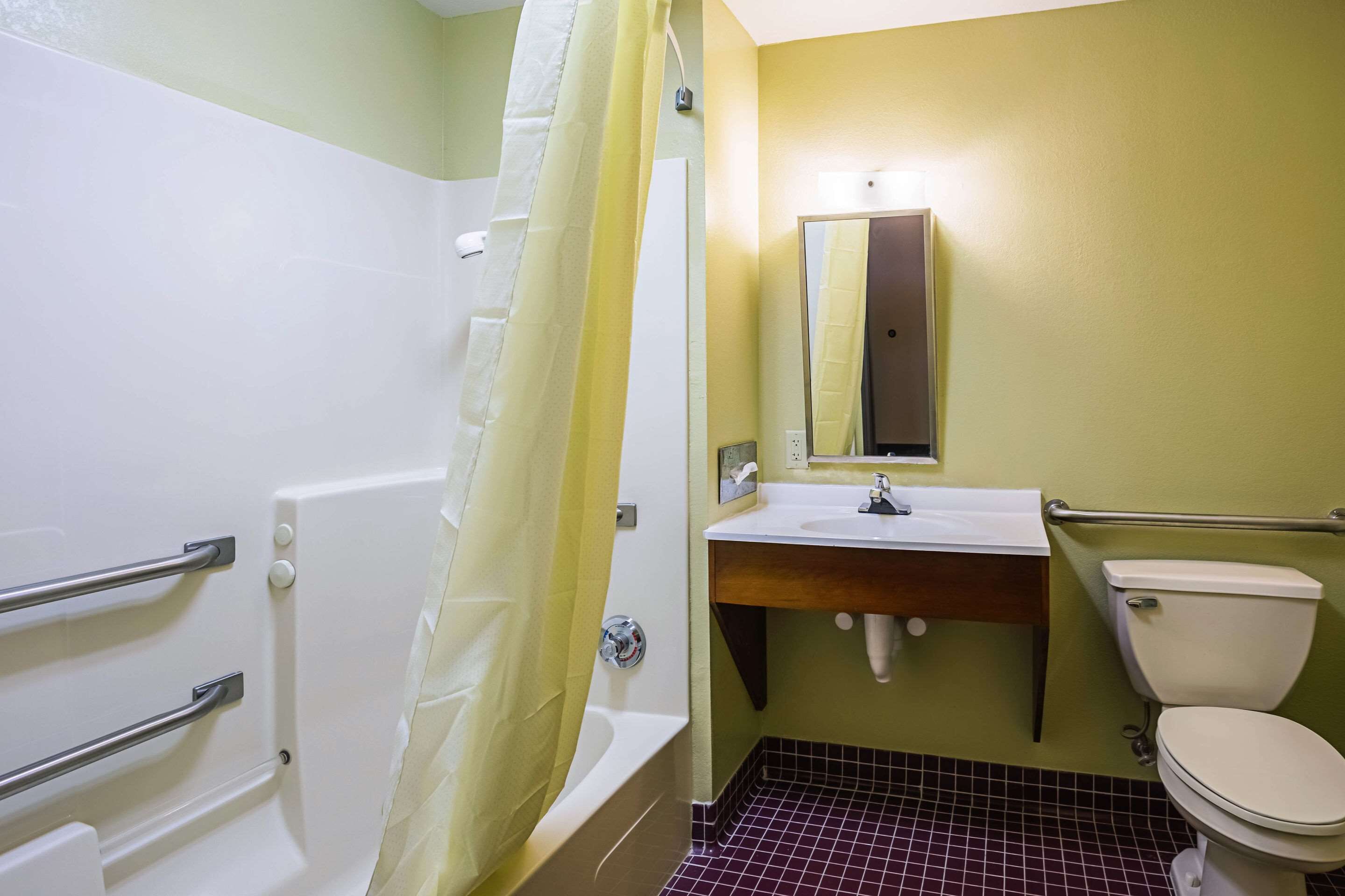 Une salle de bain avec une baignoire, un lavabo, des toilettes et un miroir.