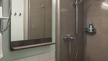 A modern bathroom with a shower, sink, and mirror.