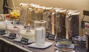 Diversos alimentos expuestos en recipientes transparentes con etiquetas, entre ellos, distintos tipos de yogur y cereales.