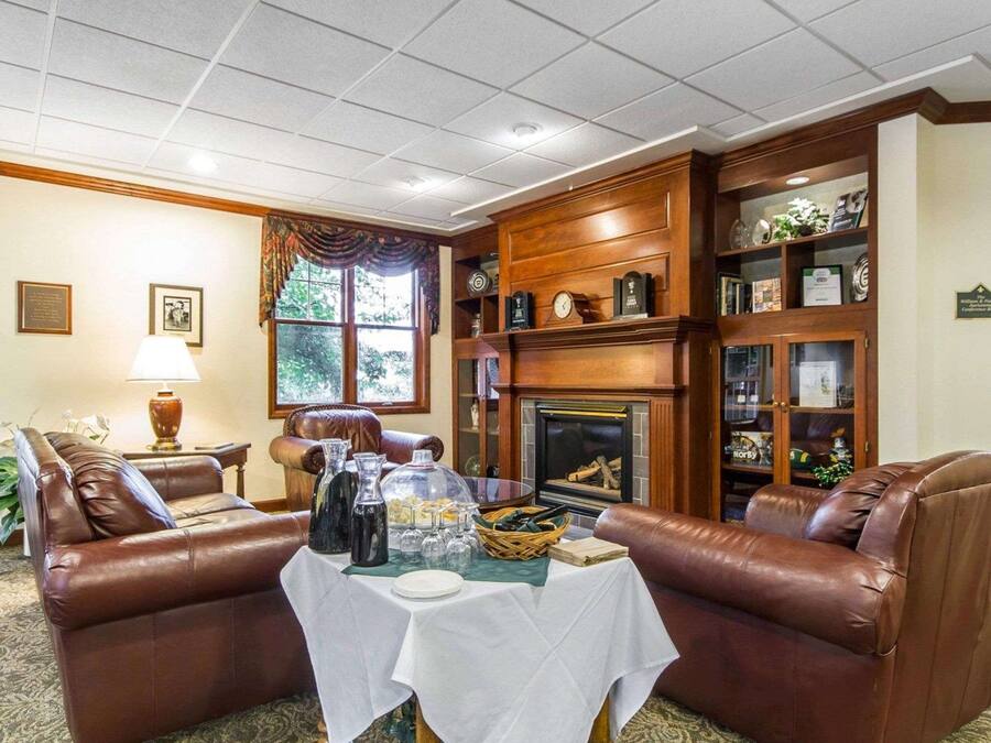 A cozy living room with leather sofas, a fireplace, and a table set for dining.