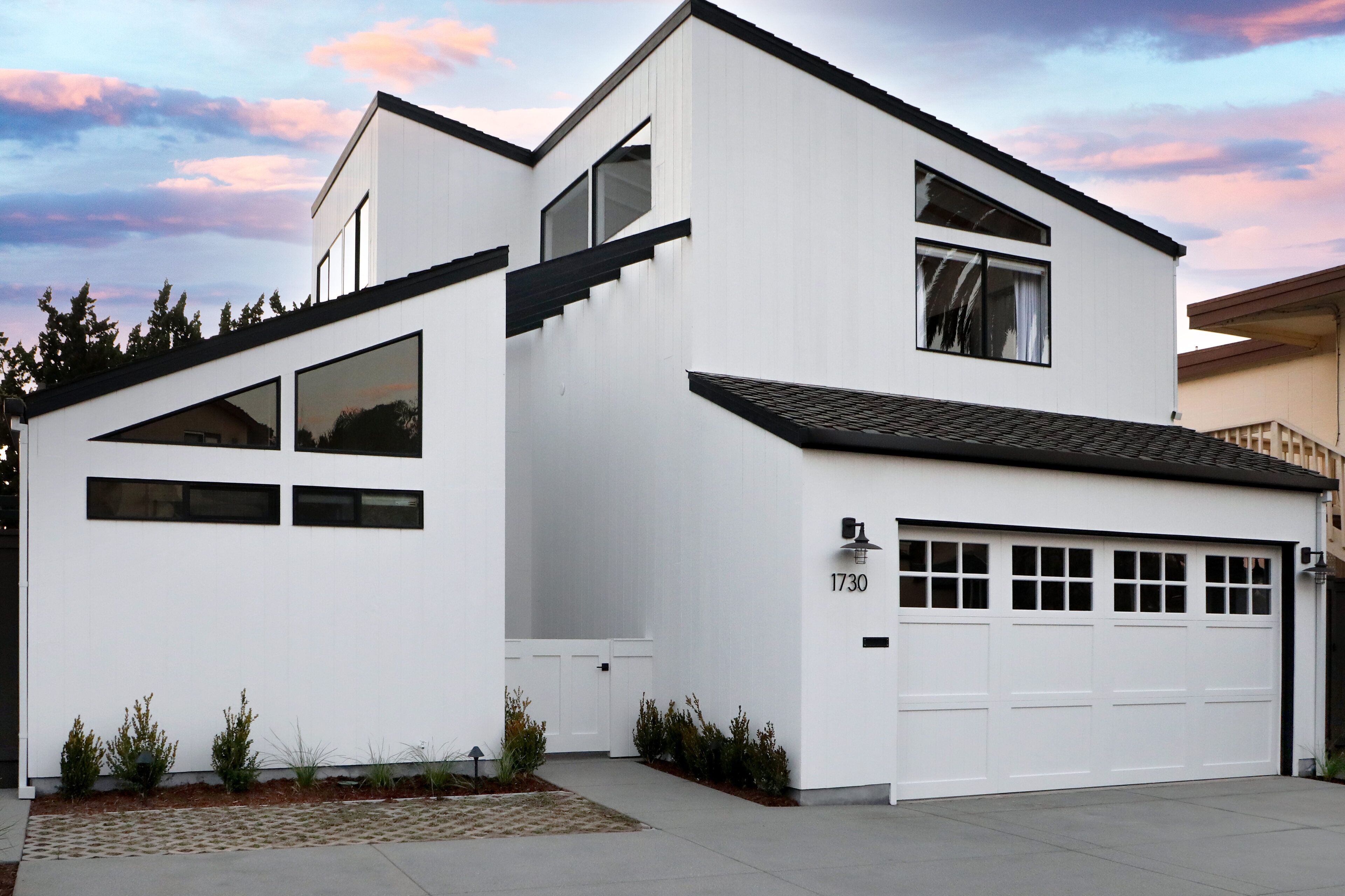 A modern two-story house with a garage, large windows, and a number 1730 on the garage door.