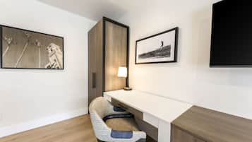A modern office space with a desk, chair, and artwork on the walls.