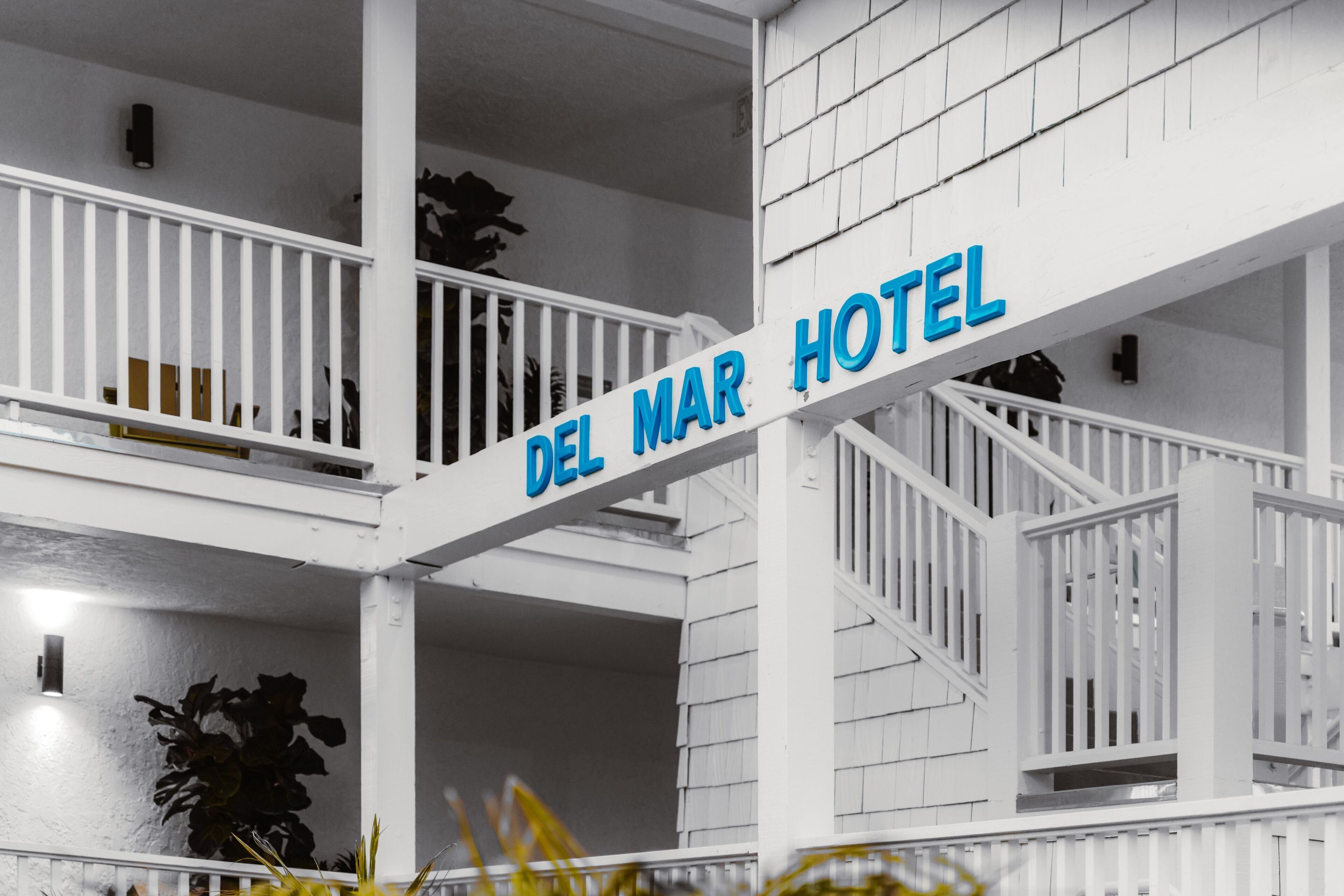 A hotel sign with the name "DEL MAR HOTEL" in blue letters on a white background.