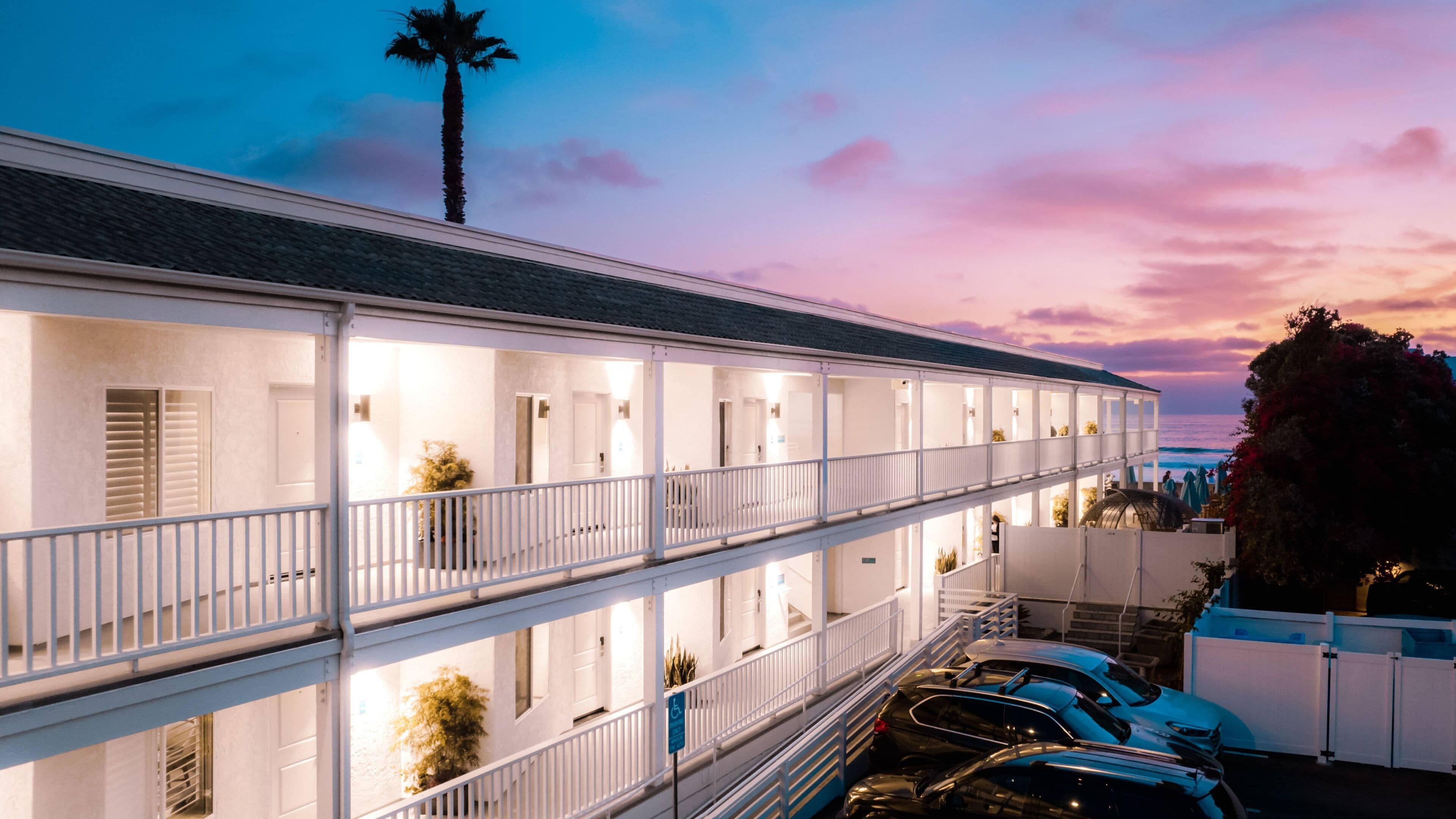 A multi-story motel with balconies and a parking area.