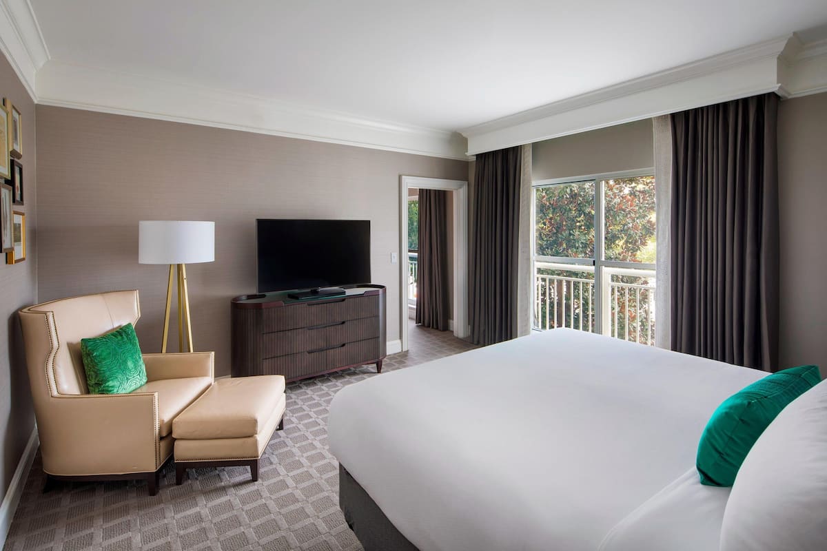 Une chambre d’hôtel avec un grand lit, un canapé, une télévision et une commode.