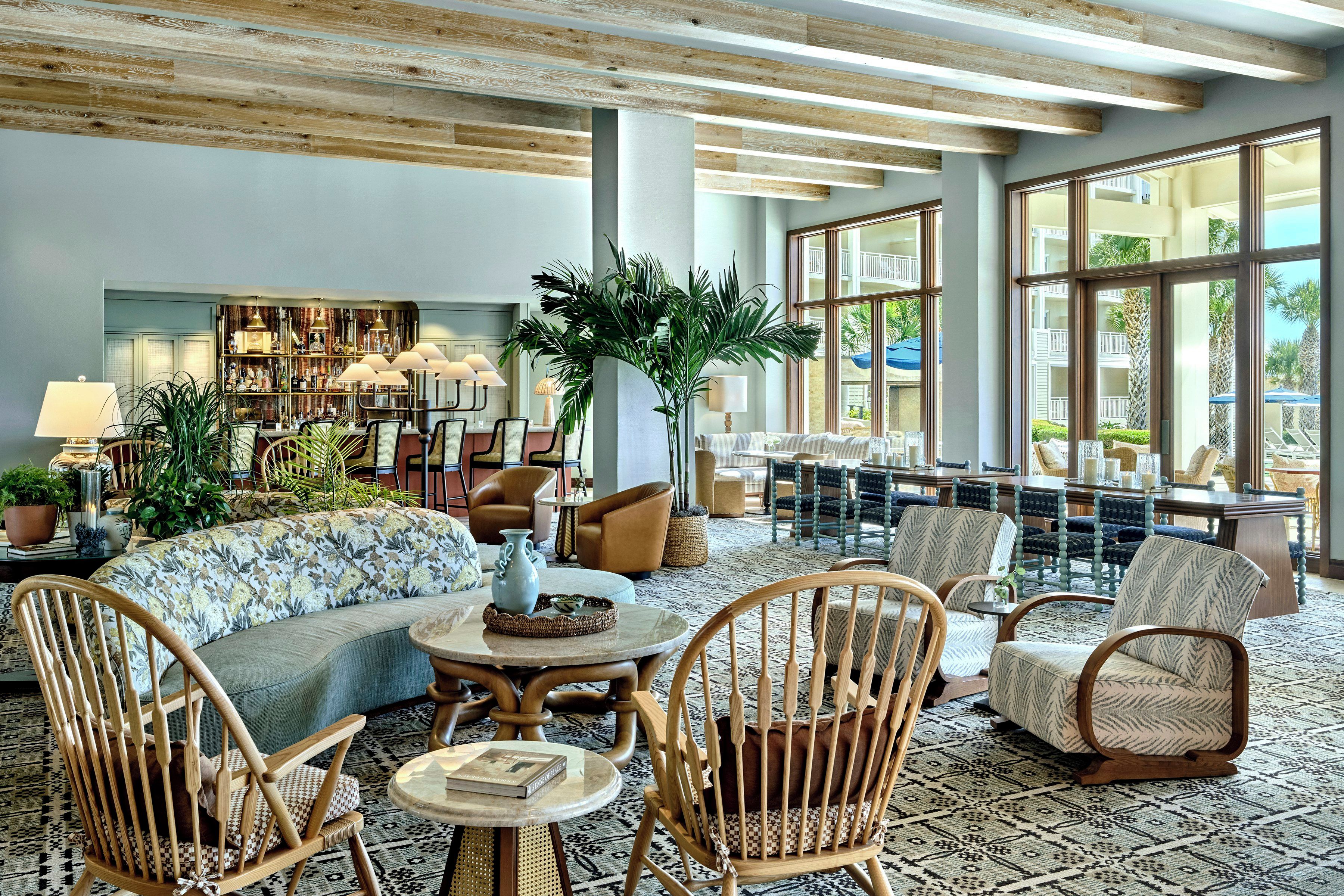 A spacious lobby with a high ceiling, large windows, and a variety of seating arrangements including sofas and chairs.
