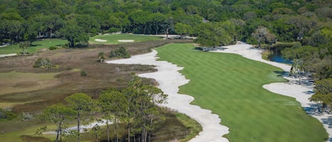 A golf course with a large building in the background.