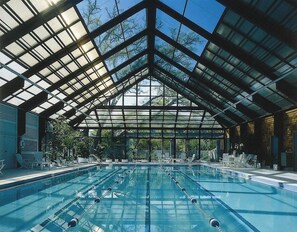 Una piscina interior con techo de cristal y múltiples carriles.