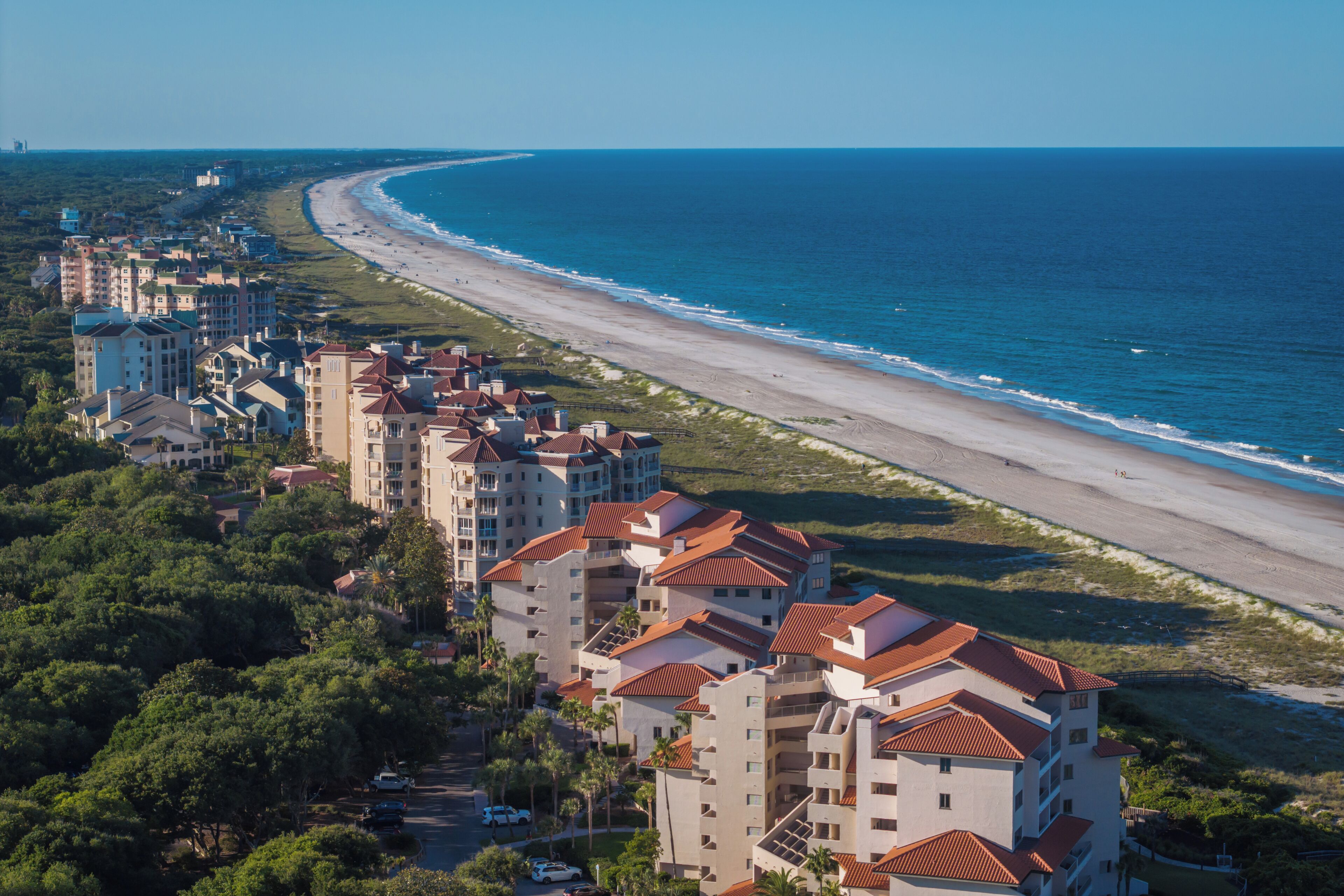 Ein Küstenhotel mit mehreren Gebäuden, einem Strand und Blick auf den Ozean.