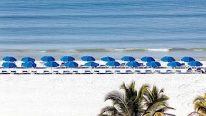 A beach with rows of blue umbrellas and white lounge chairs. - Marco Beach Ocean Resort (Marco Island)