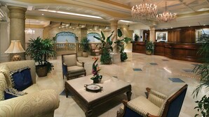 A spacious lobby with a high ceiling, chandeliers, and a reception desk. - Marco Beach Ocean Resort (Marco Island)