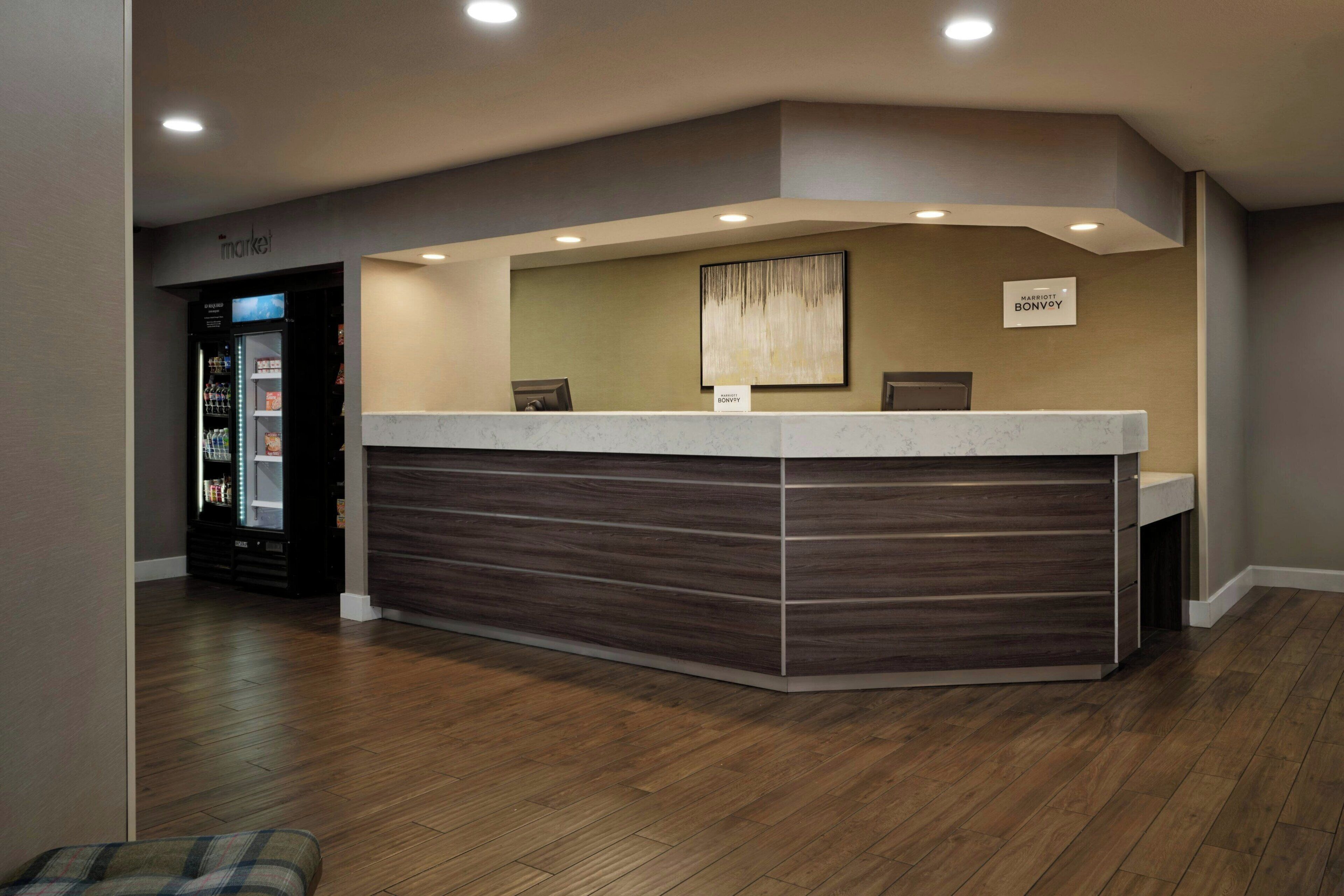 A reception desk with a nameplate, a vending machine, and a check-in counter.