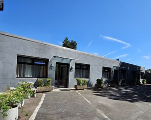 A modern building with numbered doors, large windows, and potted plants. - Concorde Hotel Ascot (Düsseldorf)