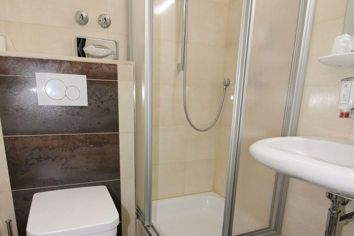 A bathroom with a shower, toilet, and sink.
