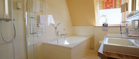 A modern bathroom with a glass-enclosed shower, a freestanding bathtub, and a vanity with a sink.