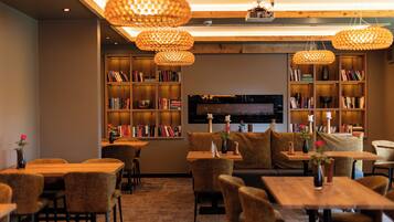 Una biblioteca acogedora con estanterías, asientos cómodos e iluminación cálida.