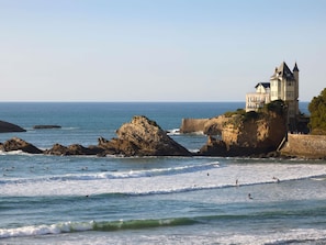 A coastal view with a castle-like building on a cliff overlooking the sea. - Le Talaia Hôtel & Spa Biarritz - MGallery Collection (Biarritz)