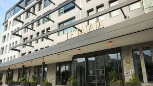 A modern hotel with a prominent sign, large windows, and outdoor planters. - Le Talaia Hôtel & Spa Biarritz - MGallery Collection (Biarritz)
