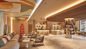 A modern lobby with a reception desk, seating area, and decorative elements. - Le Talaia Hôtel & Spa Biarritz - MGallery Collection (Biarritz)