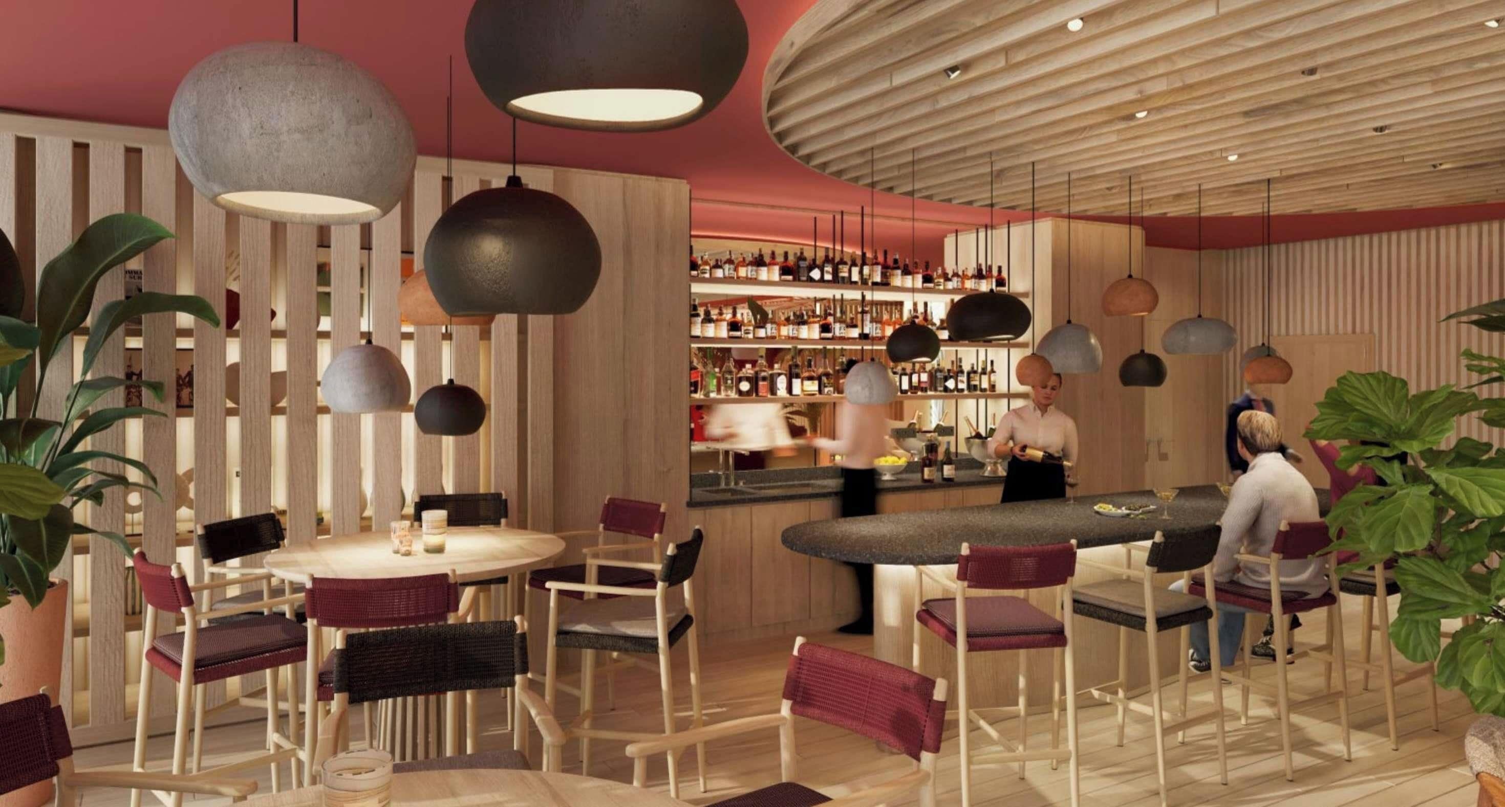 Zona de bar moderna con mesas redondas, taburetes de bar y varios candelabros colgantes.