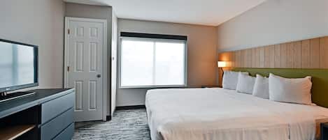 Una habitación de hotel con cama, televisión, escritorio y ventana.
