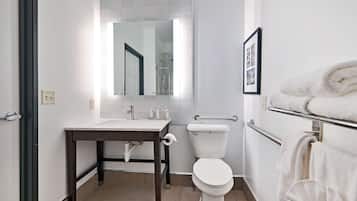 Un baño moderno con lavamanos, inodoro y perchero para toallas.