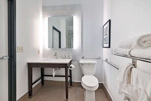 A modern bathroom with a sink, toilet, and towel rack.