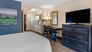 A hotel room with a bed, a desk with two chairs, a television, a minibar, and a bathroom visible through an open door. - Extended Stay America Premier Suites Miami Coral Gables (Miami)