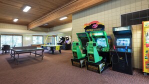 An indoor recreational area with arcade games, a ping pong table, and a large window. - Holiday Inn Express Holland by IHG (Holland)