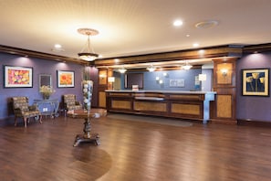 A lobby with a reception desk, seating area, and decorative elements.