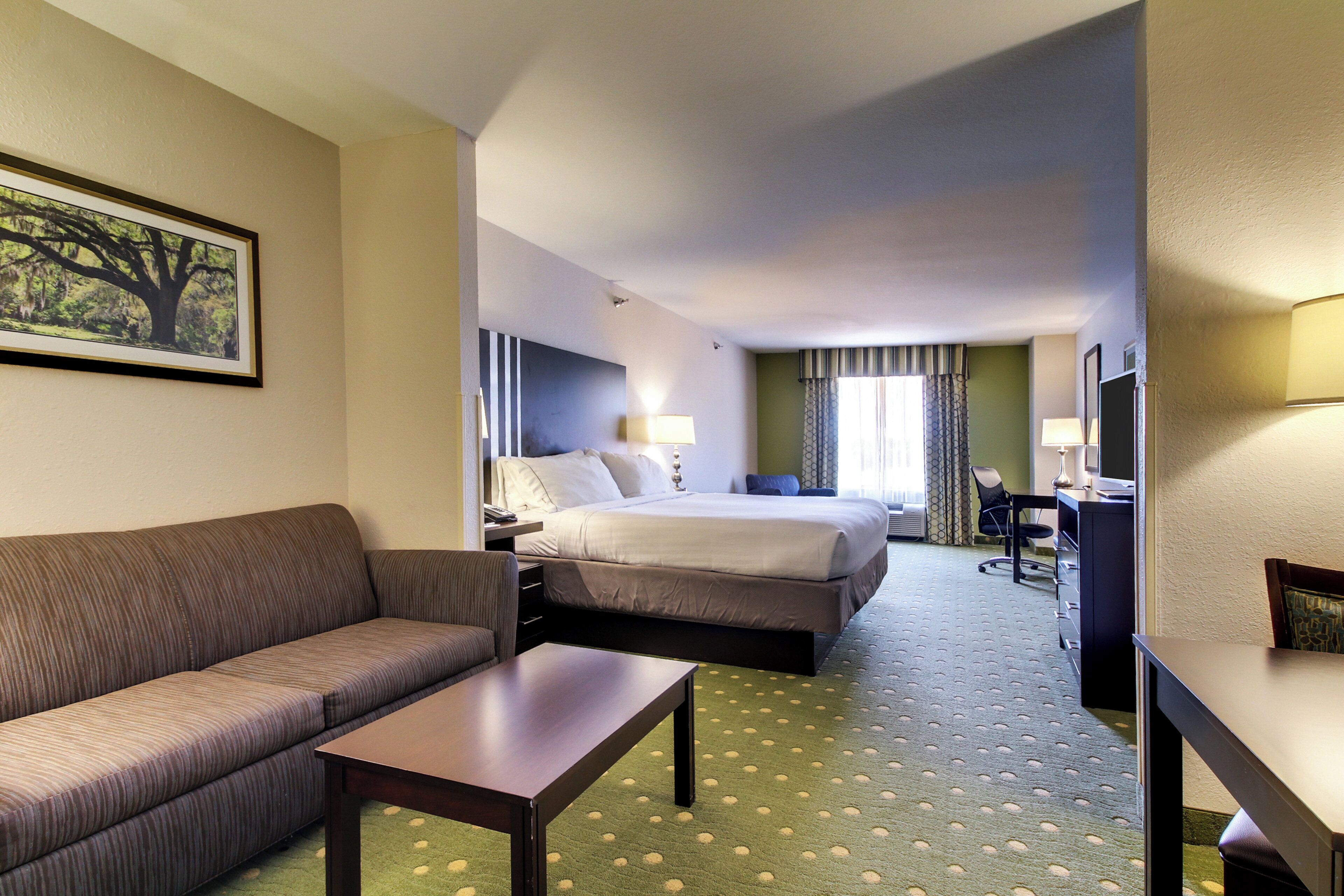 Ein Hotelzimmer mit einem Bett, einem Sofa, einem Schreibtisch und einem Fernseher.