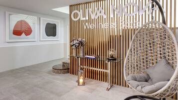 A reception area with a wooden slat wall, a hanging chair, and framed artwork.