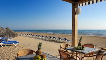 Plage, sable blanc, chaises longues, parasols