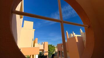 A view through a circular window of a building with a clear blue sky.