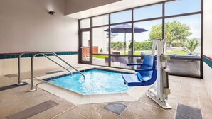 An indoor swimming pool with a view of the outdoors, a blue chair, and a water slide. - Hampton Inn Quakertown (Quakertown)