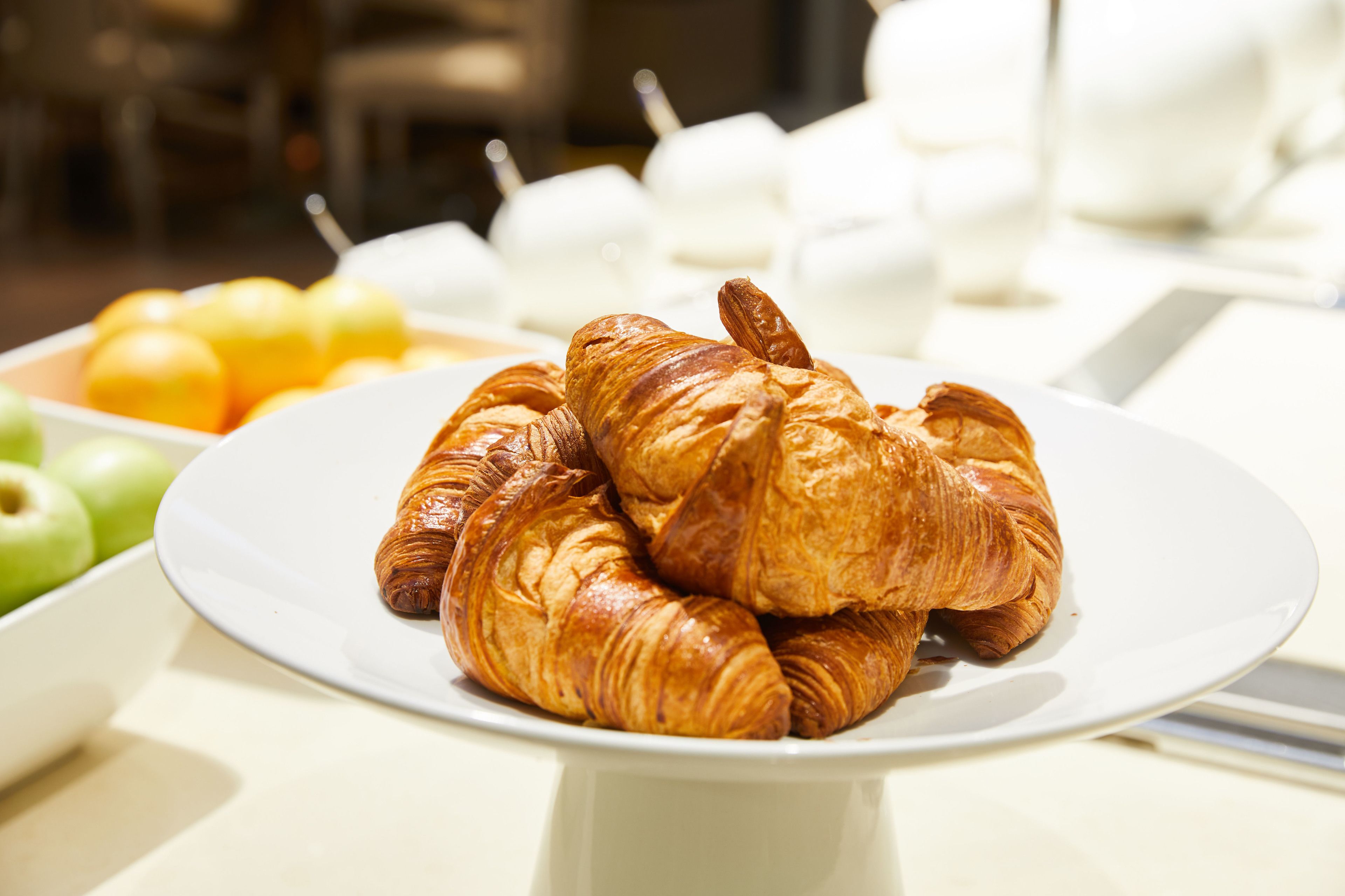 A plate of croissants on a white table.