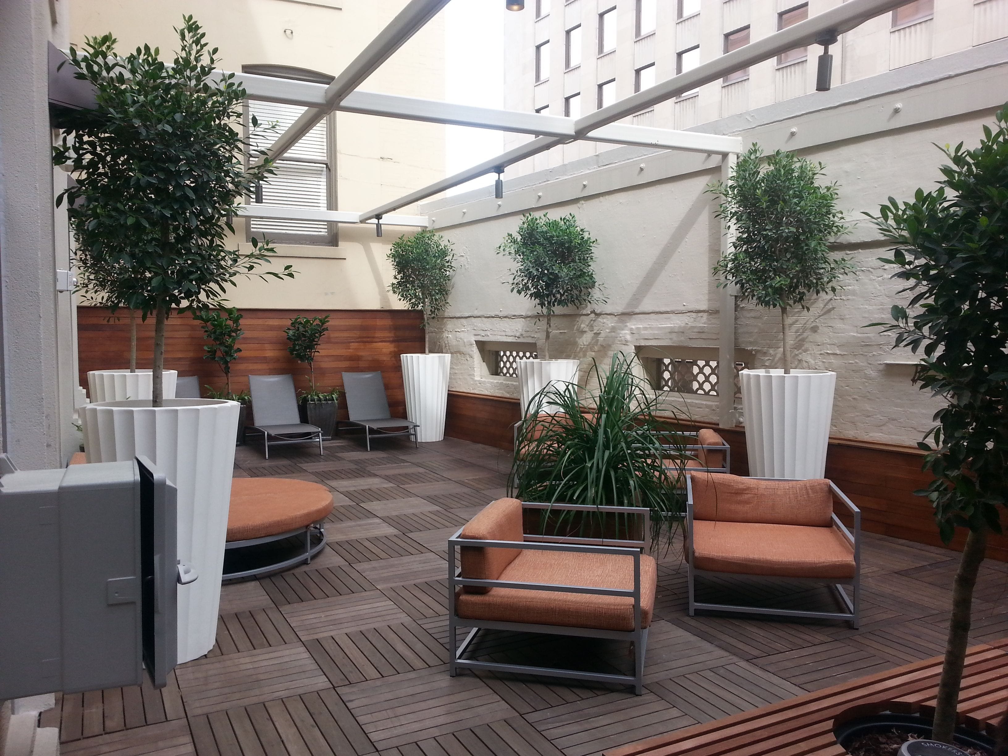 Een terras met moderne meubels en potplanten.