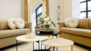 Una sala de estar moderna con dos sofás, una mesa de centro y un jarrón con flores.