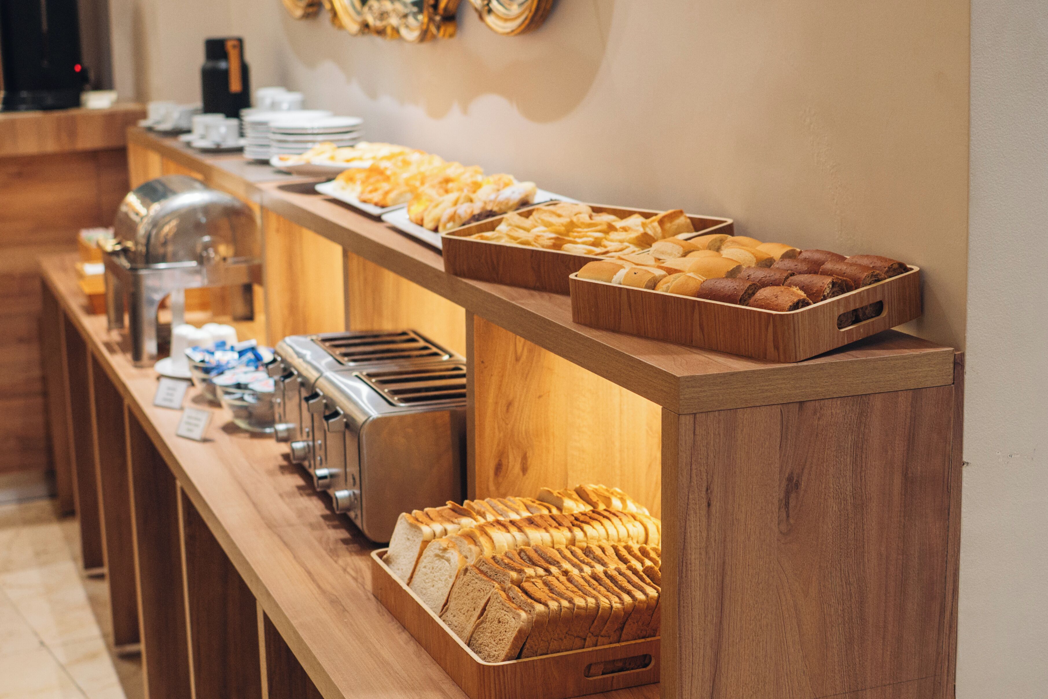 A buffet with various breads and pastries.