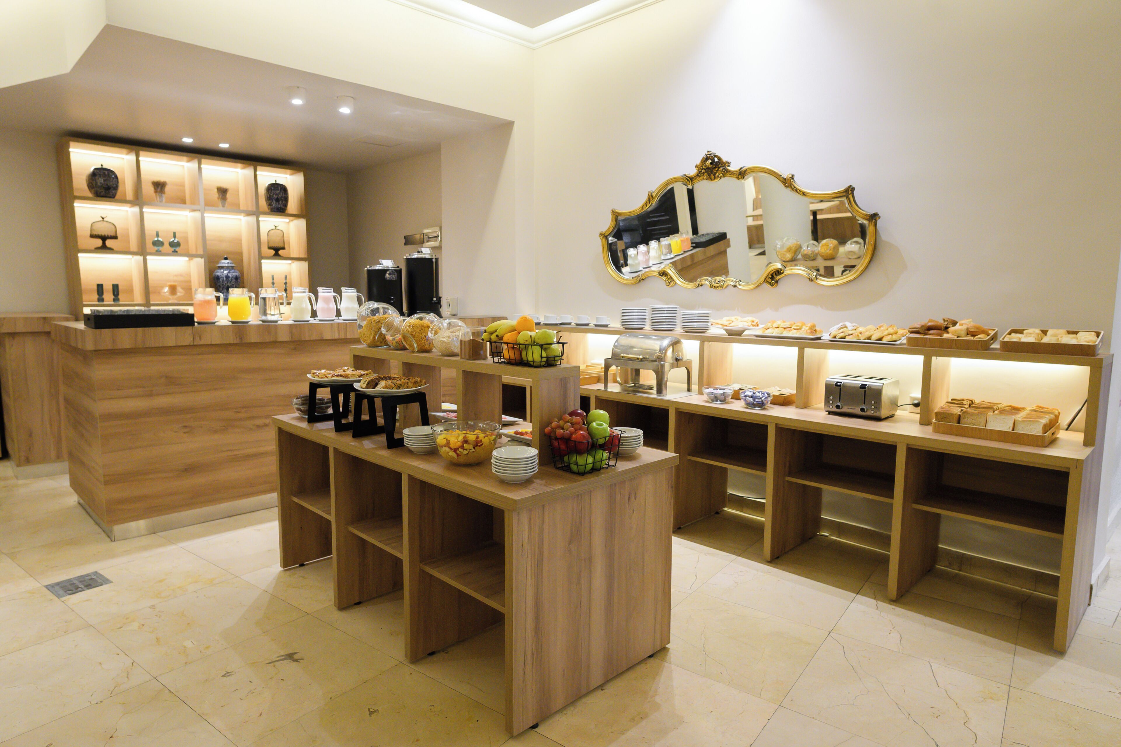 Un buffet de petit-déjeuner proposant divers plats et un miroir au mur.