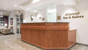 A reception desk with a wooden finish and a sign reading "Microtel Inn & Suites". - Microtel Inn & Suites by Wyndham Rice Lake (Rice Lake)