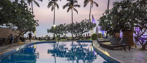 Alberca al aire libre y camastros