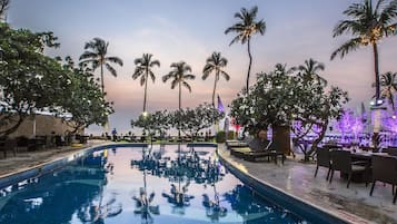 Una piscina al aire libre, sillones reclinables de piscina