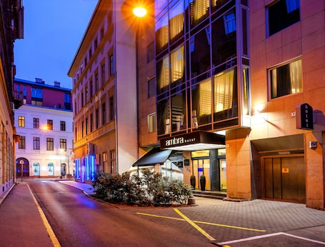 A hotel entrance with a modern facade, a visible entrance, and a clear pathway leading to the door.