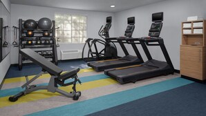A gym with treadmills, a bench, and exercise balls.