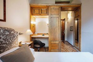 A hotel room with a bed, a desk, a chair, and a wooden partition. - Guest House Morandi (Florence)